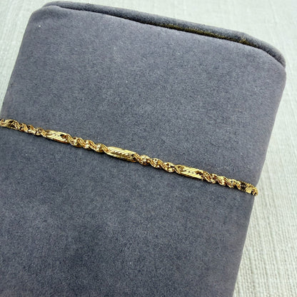 Gold bracelet on a gray cushion