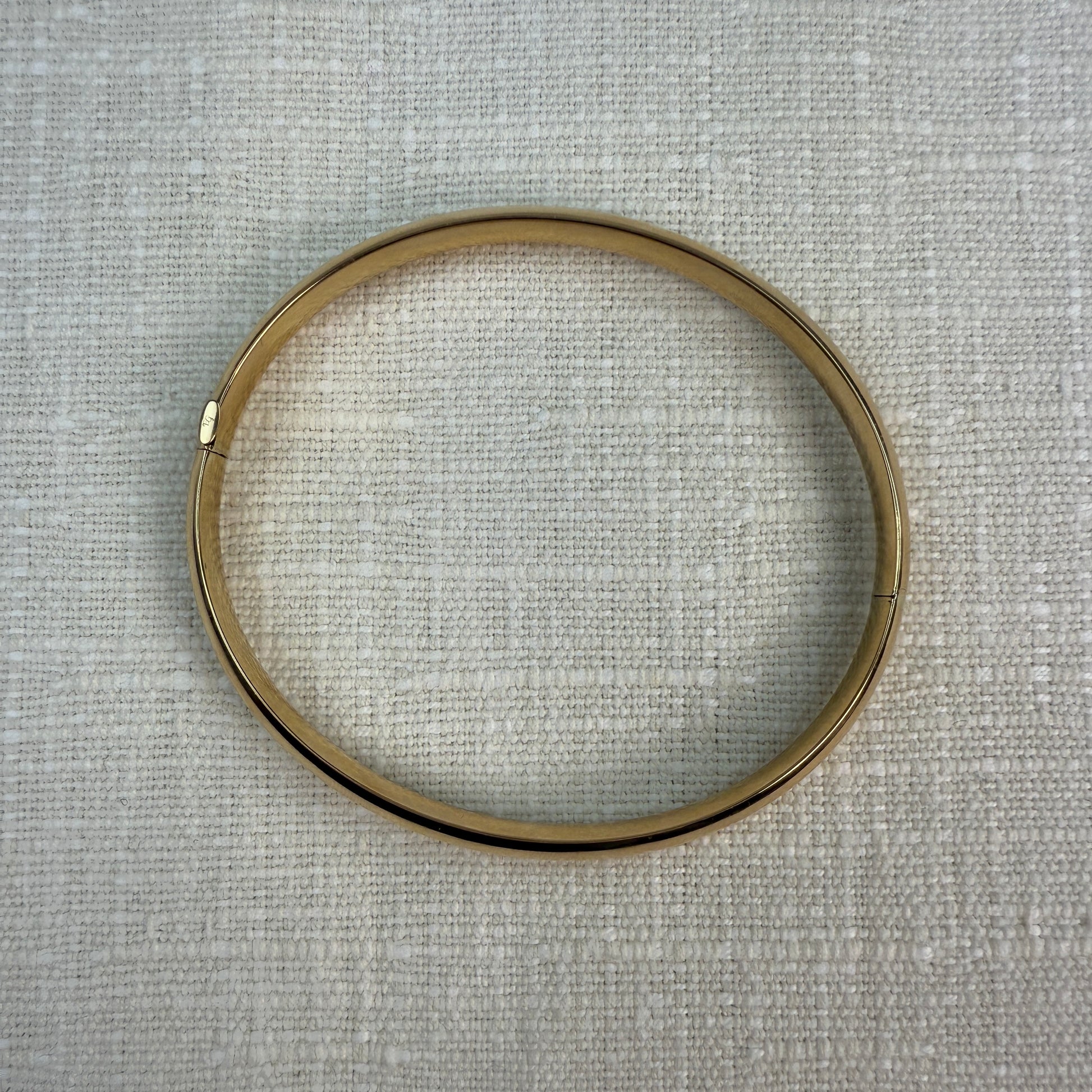 Top view of oval gold bangle.
