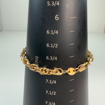 Chunky link gold bracelet on a black mandrel with white inch markings, measuring 7 inches.