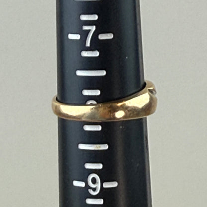 Gold ring on a black measuring tool with white markings