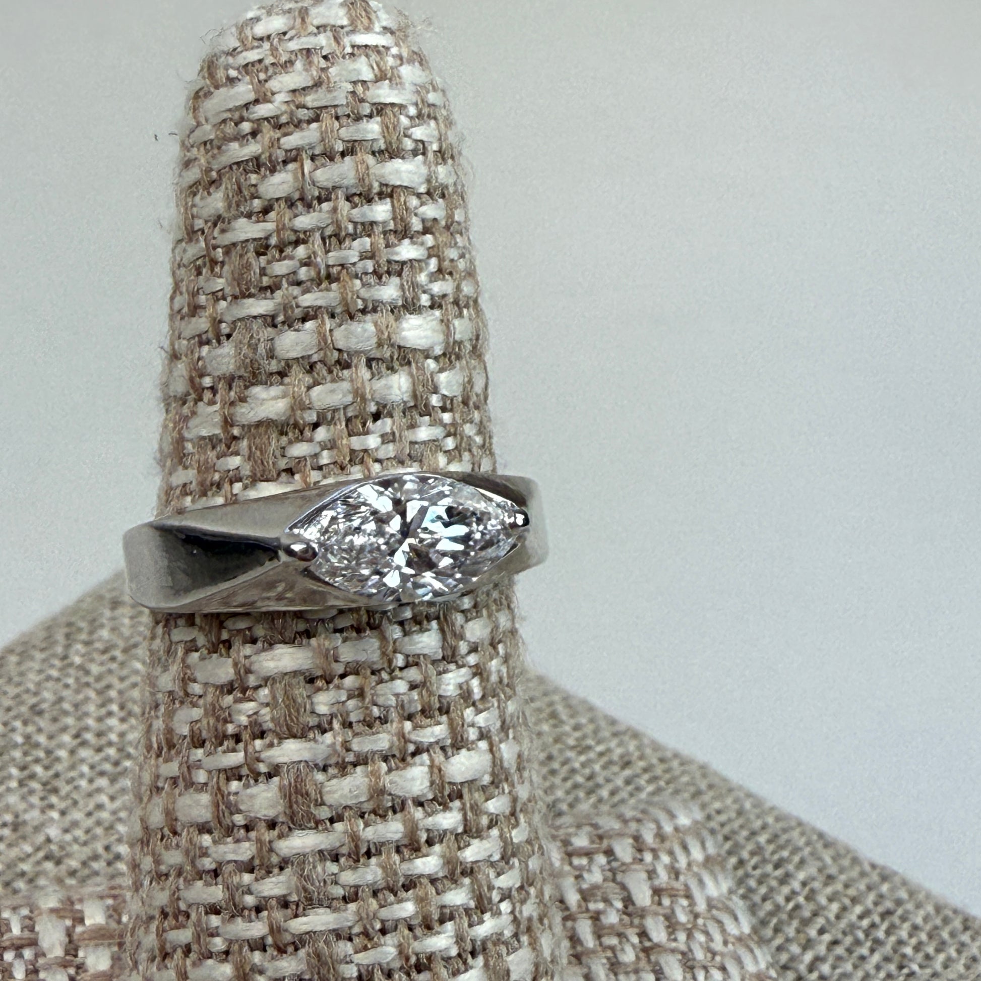 White gold and a 1-carat lab marquise diamond on a textured ring stand. 