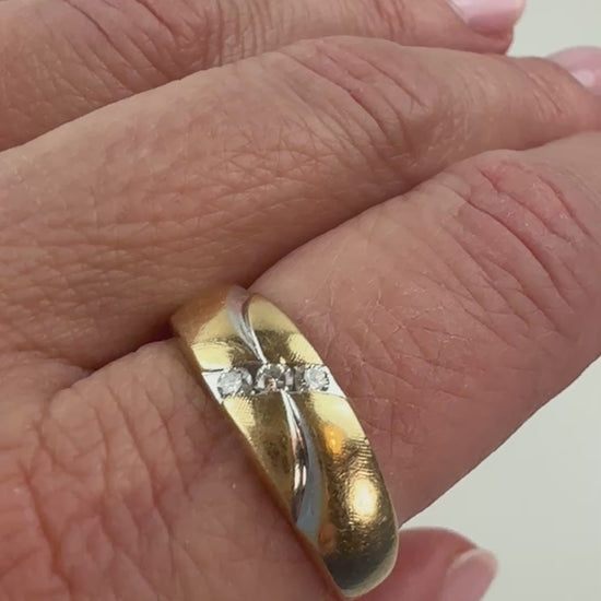 two-tone gold ring with three diamonds and wave pattern slowly moving on hand. 