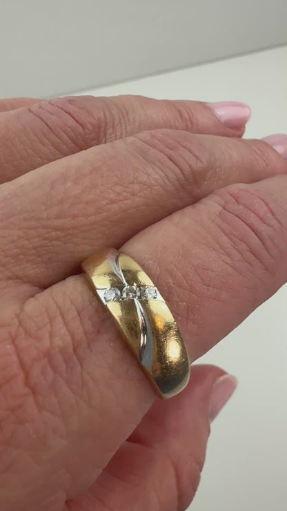 two-tone gold ring with three diamonds and wave pattern slowly moving on hand. 