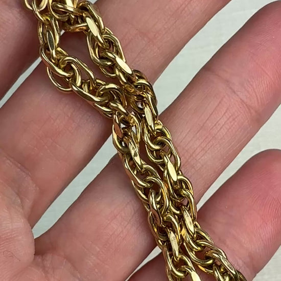 Short video of a chunky gold bracelet gently moved in hand to show surface shine.