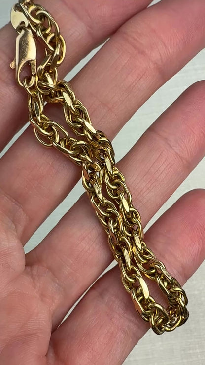 Short video of a chunky gold bracelet gently moved in hand to show surface shine.
