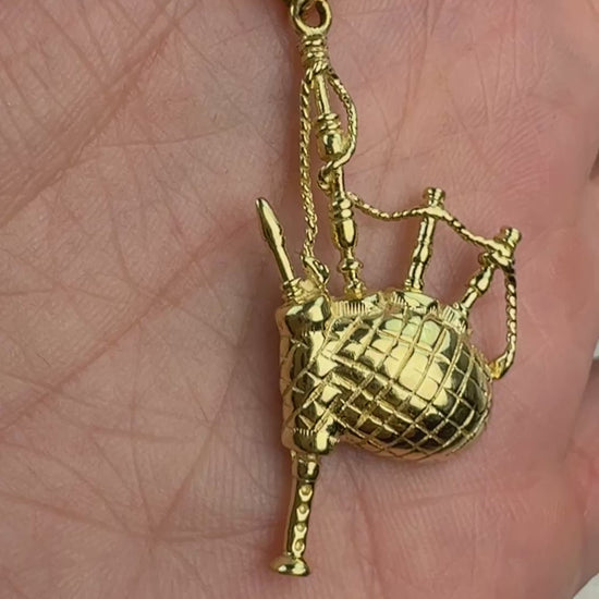 Video of 14k gold backpipes slowly moving in a hand