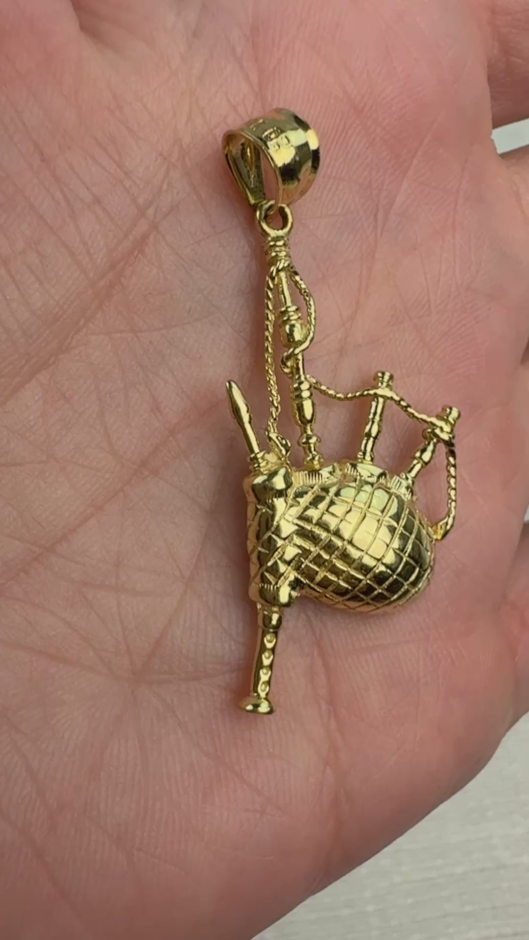 Video of 14k gold backpipes slowly moving in a hand